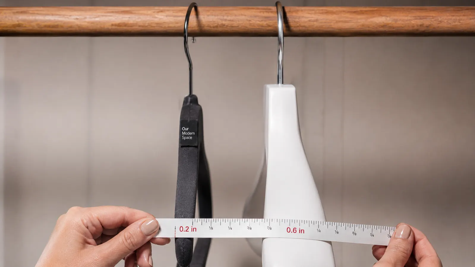 Side-by-side close-up of a velvet hanger and a thick white plastic hanger on the same closet rod showing width difference